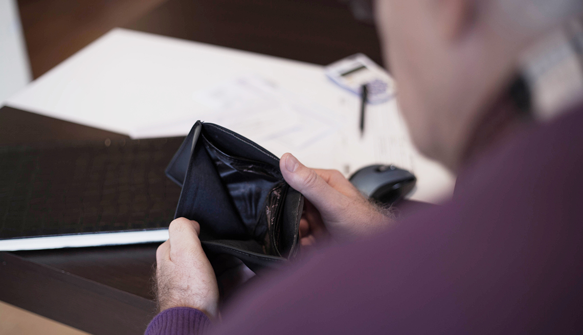 Older adult holding an empty wallet.