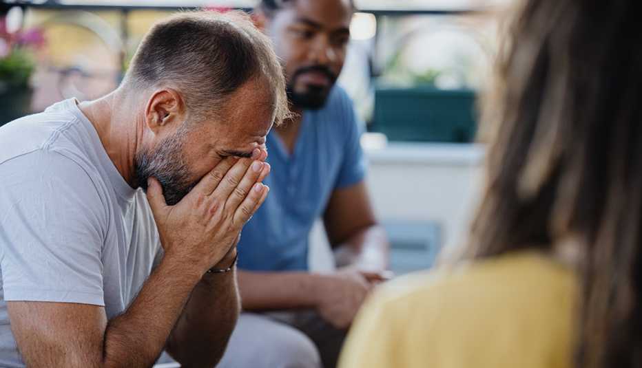a man looks upset while in a group therapy session