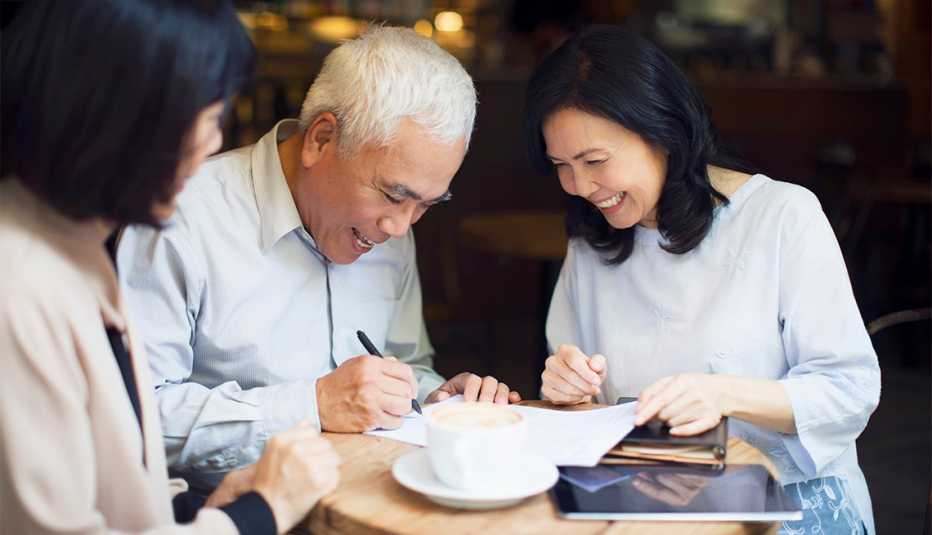 couple signing financial agreement with their financial advisor.