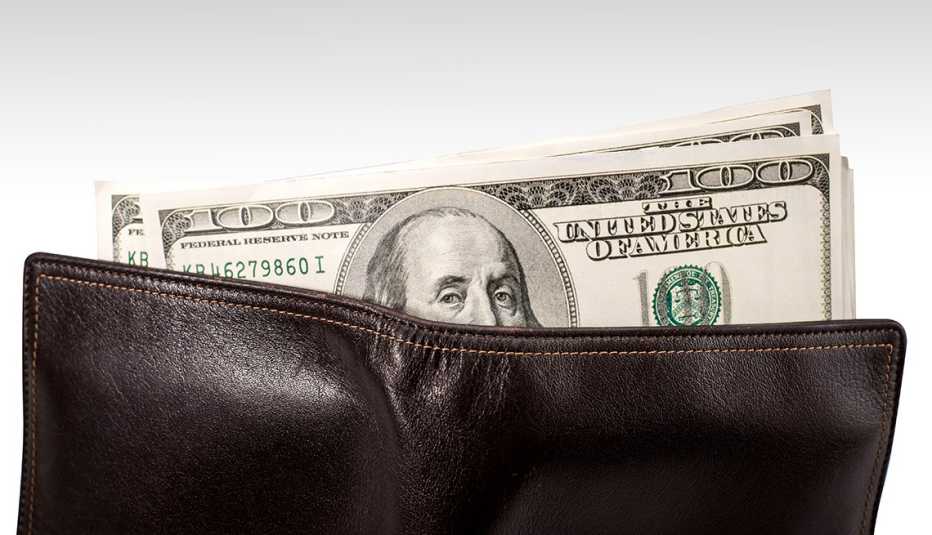 Brown leather wallet with money hanging out