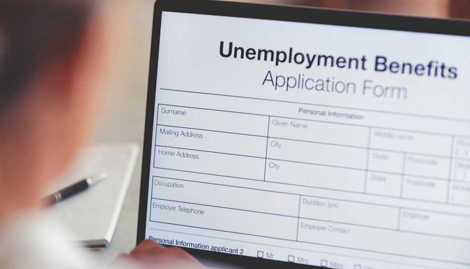 Woman filling out an online unemployment benefits application form. She is using a laptop computer