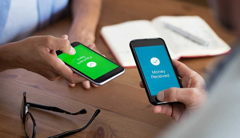 Closeup hands holding mobile phone with application for send and receive money. Man and woman holding smartphone and making payment transaction. Smart phone screen displaying payment sent and money received message after transaction.