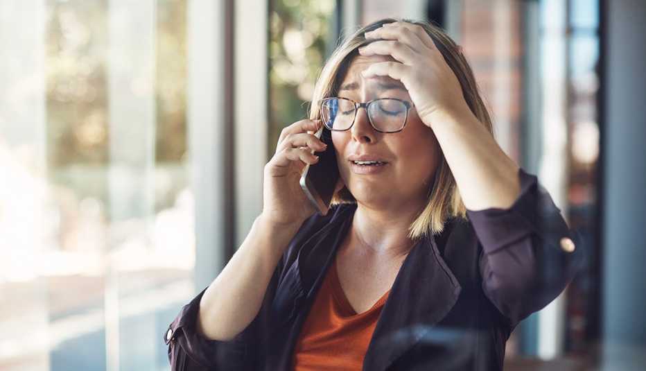 A woman is getting bad news while on the phone