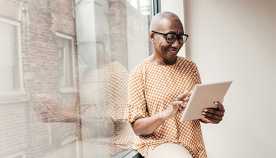 A woman using a tablet inside by a window