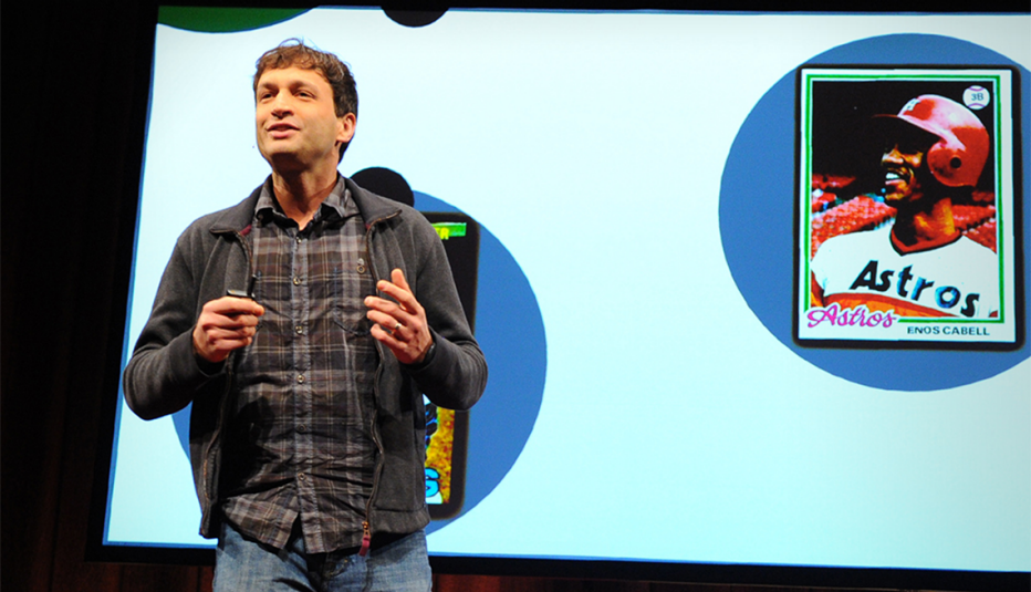 A man, Ron Gutman, speaking on stage at a TED event