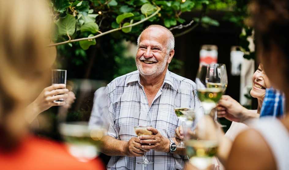 A man making a toast at an outdoor social gathering