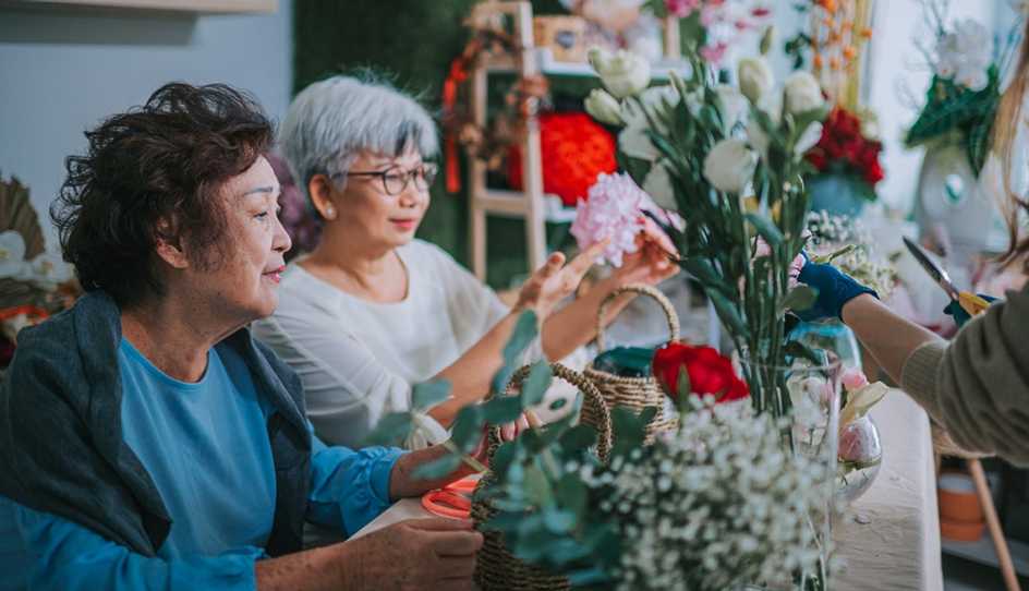 Two women flower arranging inside of a flower shop