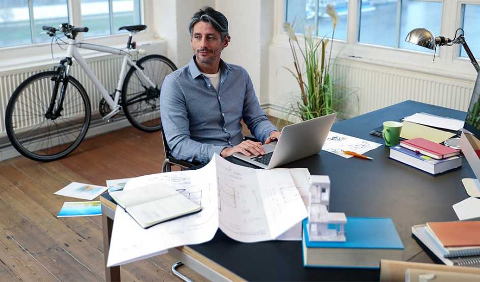 A man using a laptop at a desk in an office