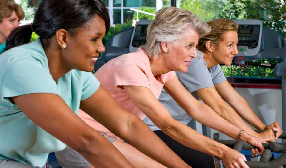 A group of women on exercise bikes in a gym