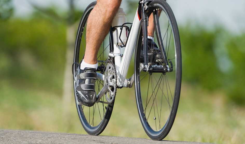 A view of a person’s legs pedaling a bike outside